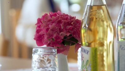 Getränkeflasche mit Glas und Hortensie