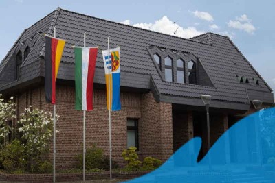 Vor dem Rathaus der Gemeinde Niederkrüchten in Elmpt hängen die Flaggen des Bundes, des Landes und der Gemeinde