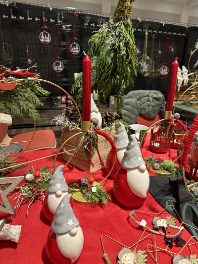 Weihnachtliche Dekoration unter anderem mit Kerzen, Wichteln und Tannenzapfen