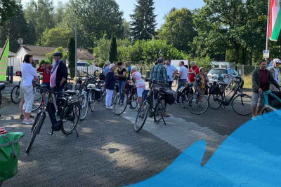 Eine Gruppe Radfahrerinnen und Radfahrer auf einem Parkplatz