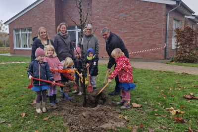 Kinder und Erzieherinnen der Kita "Unter´m Regenbogen" auf dem Außengelände der Kindertagesstätte beim Pflanzen eines Baumes gemeinsam mit Bürgermeister Karl-Heinz Wassong und Klimaschutzmanagerin Lea Korall