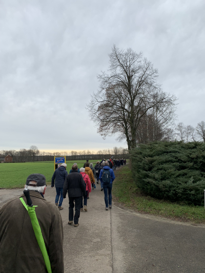 Voettocht 30 Dezember Mehrere Personen die zusammen einen Weg entlang wandern.