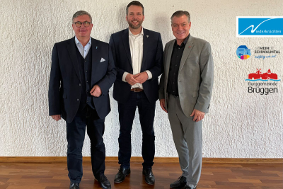 Die Bürgermeister Karl-Heinz Wassong (Niederkrüchten), Andreas Gisbertz (Schwalmtal) und Frank Gellen (Brüggen). Daneben die Logos der drei Gemeinden.
