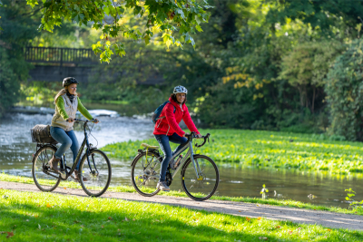 Zwei Radfahrerinnen fahren englang eines Flusses. (Foto: Patrick Gawandtka)