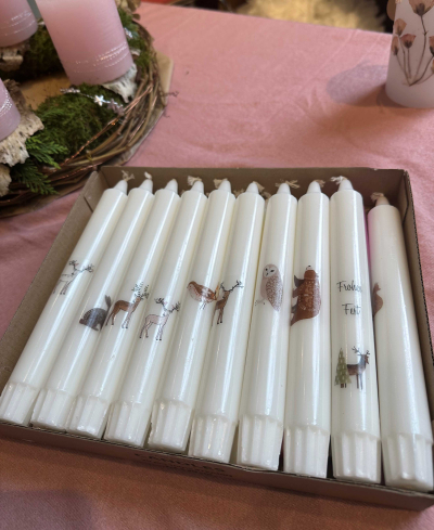 Weiße, langstielige Kerzen mit herbstlichen Motiven