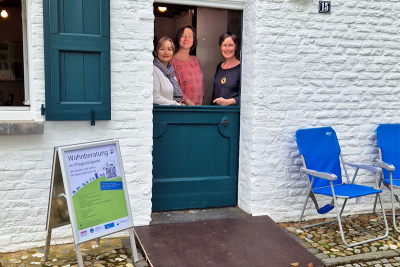 Peggy Löhr und Marion Küpper (Seniorenberatung Gemeinde Niederkrüchten) und Angela Avenia (Wohnberatung) hinter der zweigeteilten Eingangstür von Haus Hansen