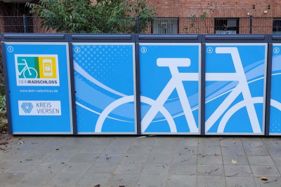 Blick auf eine DeinRadschloss-Radbox im Kreis Viersen. Darauf das Piktogramm eines Fahrrads sowie die Logos von "DeinRadschloss" und dem Kreis Viersen (Quelle: Kreis Viersen)