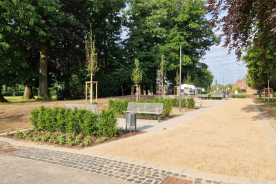 Blick auf den neuen Geh- und Radweg am Ende der Poststraße in Elmpt. Links Bänke und Bäume sowie im Hintergrund eine Bouelebahn